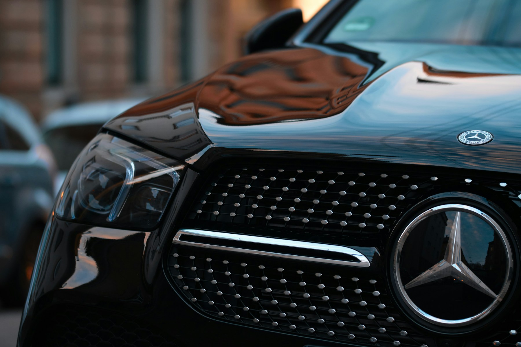 Front grille and headlight detail of a black Mercedes-Benz